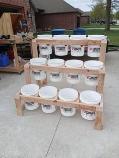 several buckets are stacked up on a wooden rack