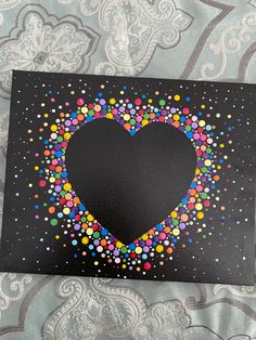 a heart made out of colorful dots on a black background with white and blue designs