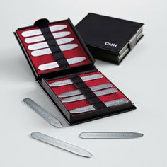 three pairs of scissors in a black box with red linings and two sets of blades