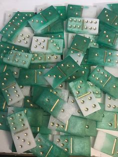 green and white squares with gold dots on them are arranged in a square pattern, as well as several smaller ones