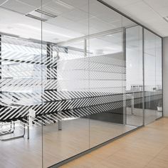 an office with glass walls and wooden floors