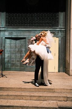a bride and groom kissing on the steps