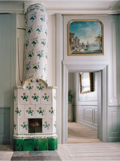 a fireplace in the middle of a room with paintings on the walls and flooring