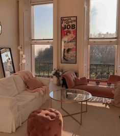 a living room filled with lots of furniture next to two large windows and a painting on the wall