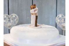 a wedding cake with a bride and groom figurine on top