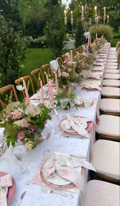 a long table is set with pink and white place settings