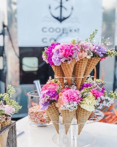 ice cream cones with flowers in them on a table