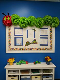 a bulletin board on the wall in a classroom with flowers and plants growing from it