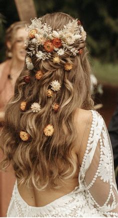 the back of a woman's head with flowers in her hair and other people standing around