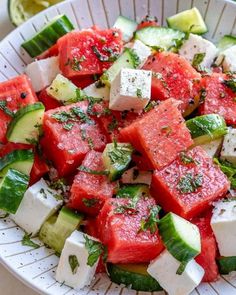 watermelon, cucumber and mint salad in a white bowl on a table