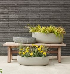 two large planters sitting on top of a wooden bench