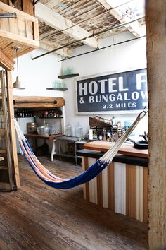 a hammock hanging from the ceiling in a room with wooden floors and walls