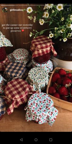 some strawberries are sitting on the table next to flowers and other things in baskets