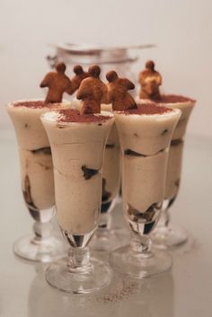 three glasses filled with desserts on top of a table