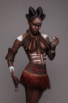 a woman in an african costume poses for the camera with her hands on her hips
