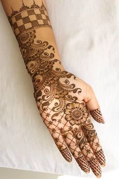 a woman's hand is decorated with hennap and intricate designs on it