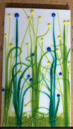 an art glass painting with green and blue flowers