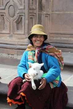 a woman sitting on steps holding a white cat