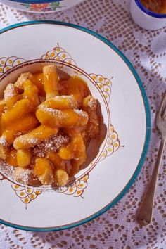 a plate topped with powdered sugar covered dessert next to two bowls filled with fruit