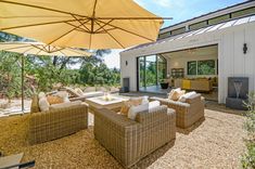 an outdoor living area with wicker furniture and umbrellas
