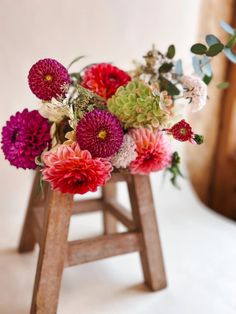 an arrangement of flowers in a wooden stand