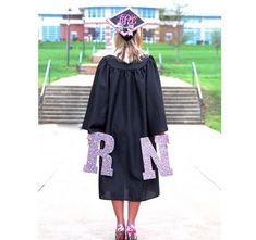 a girl in her graduation cap and gown is standing on the steps outside with her name written on it