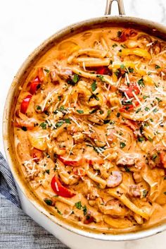 a large pot filled with pasta and meats on top of a white countertop
