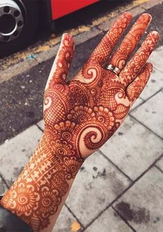 a hand with henna tattoos on it