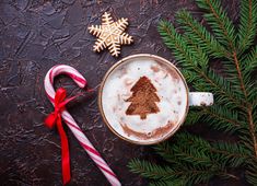 a cup of hot chocolate with a christmas tree drawn on it and candy canes