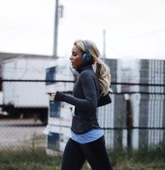 a woman running in the street with headphones on