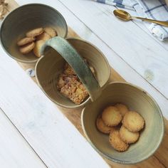 three bowls filled with food on top of a wooden table