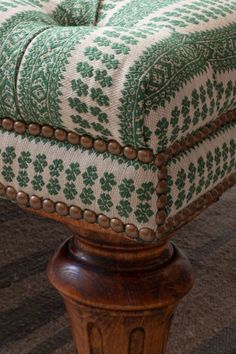a green and white ottoman sitting on top of a rug