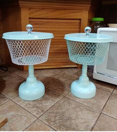 two blue plastic baskets sitting on top of a kitchen floor