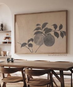 a painting hanging on the wall above a dining room table