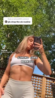 a woman is taking a selfie with her cell phone while wearing a white sports bra