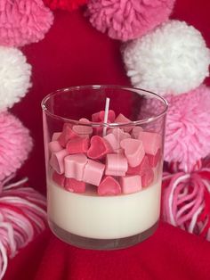 a glass filled with marshmallows on top of a red blanket
