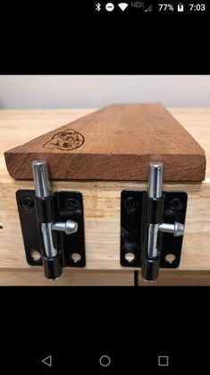 a wooden box with two metal latches on it
