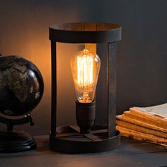 a light bulb sitting on top of a table next to a pile of books and a globe