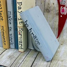 several books are stacked on top of each other in front of a wooden shelf with a red heart