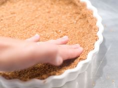 a person reaching into a pie crust