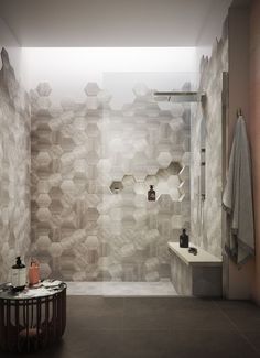 a modern bathroom with hexagonal tiles on the wall and floor, along with a walk in shower
