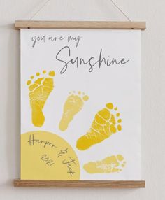 a hand and foot print hanging on a wall next to a sign that says you are my sunshine