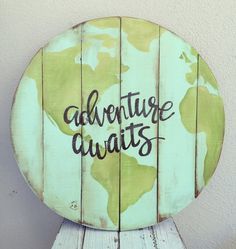 a wooden sign with the words adventure awaits on it