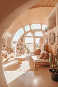 a living room filled with furniture and lots of windows next to a cactus plant in a pot