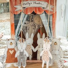 some paper rabbits are standing in front of a tent with a sign that says melly's theater