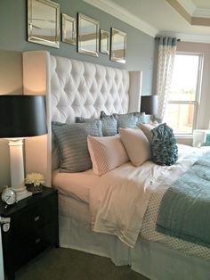 a bedroom with a bed, nightstands and pictures on the wall above it's headboard