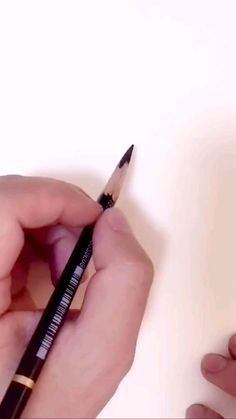 a person holding a pencil in their left hand