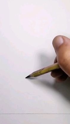 a person is holding a pencil and writing on a piece of paper that has been drawn
