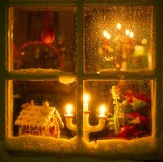 a window that has candles in it and some christmas decorations on the windowsills