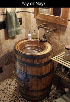 a wooden barrel sink in a bathroom next to a mirror